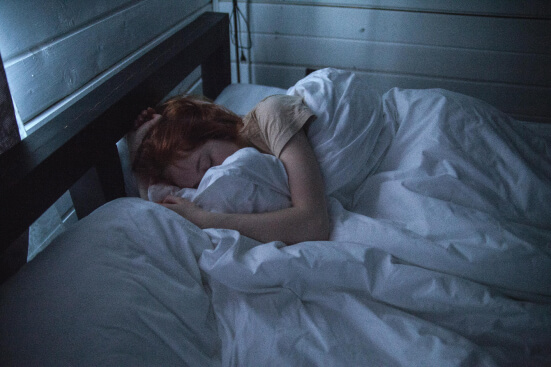 orange hair girl sleeps in bed