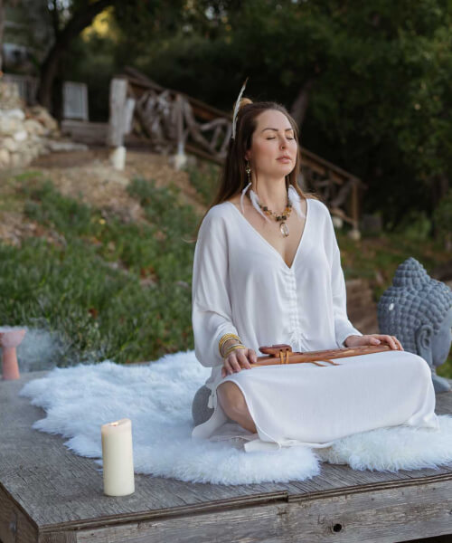 girl wearing white dress does outdoor meditation