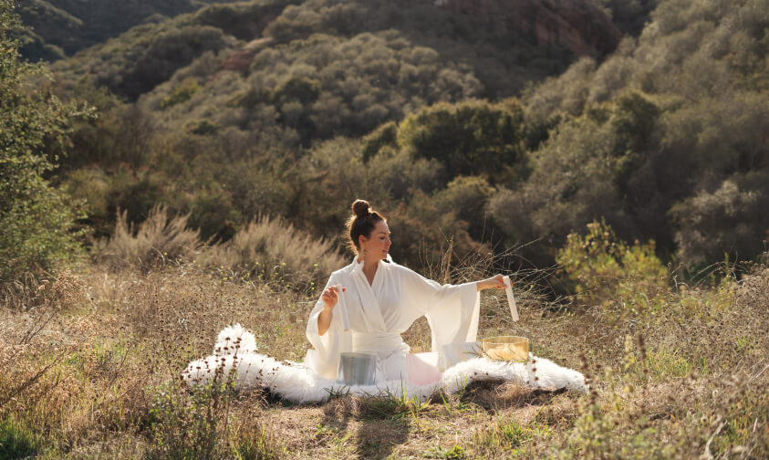 girl seating outdoor and playing sound healing bawls