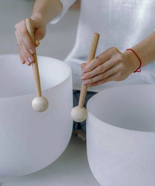 person is playing on white sound healing instrument